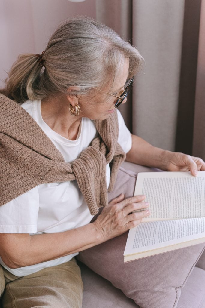 A woman taking some time to relax and read an old classic book.