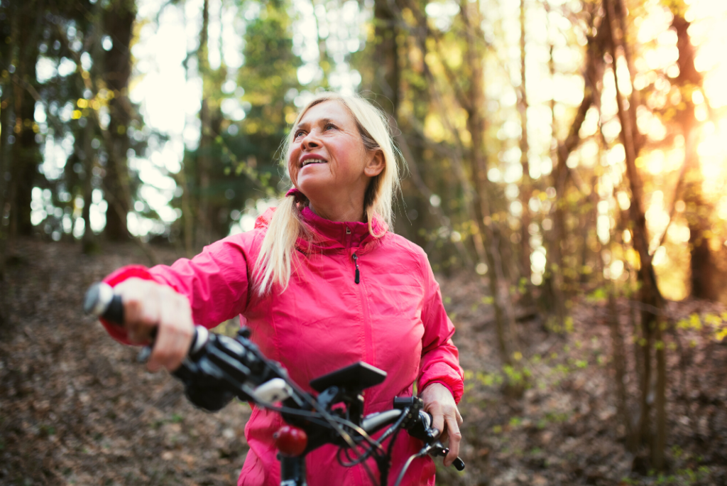 happy woman e-biking in the forest